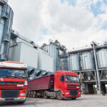 Agricultural Silo - Building Exterior, Storage and drying of grains, wheat, corn, soy, sunflower and two trucks waiting